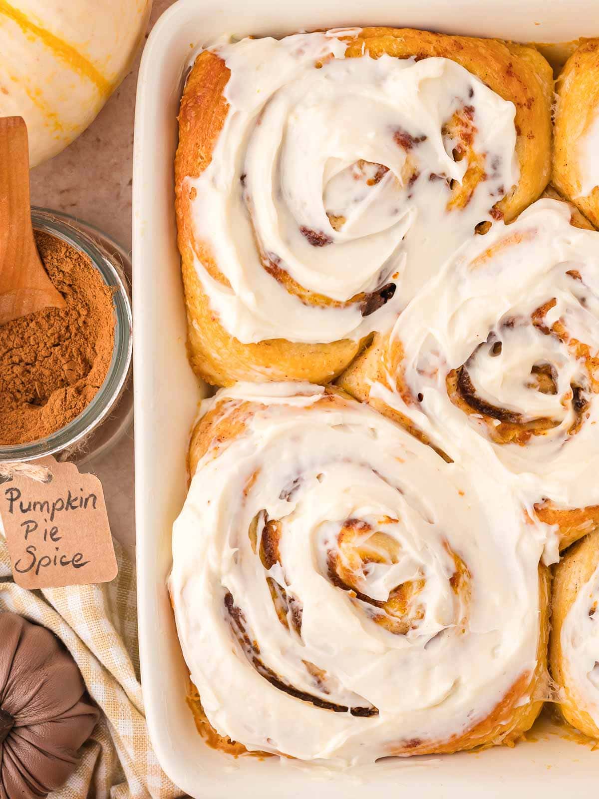 Up close of Pumpkin Cinnamon Rolls with maple cream cheese frosting.