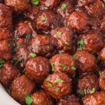 Upclose shot of cranberry meatballs cooked in a while slow cooker.