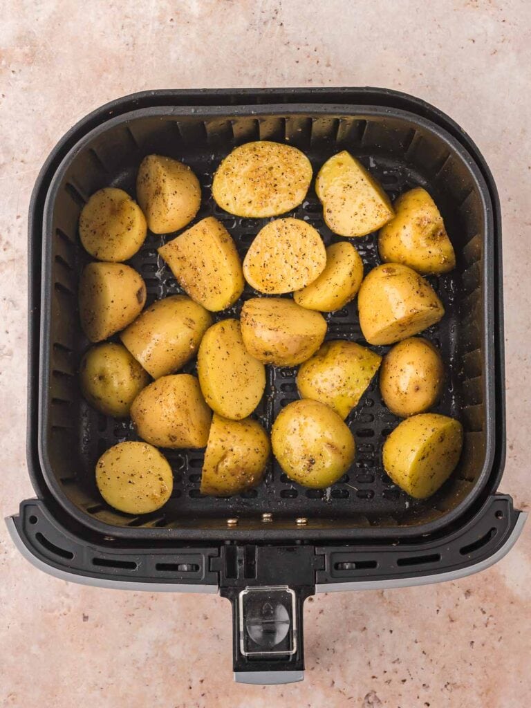 Uncooked potatoes in an air fryer.