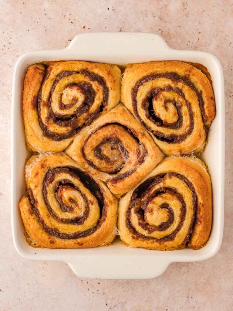 Baked cinnamon rolls in an 8x8 dish.