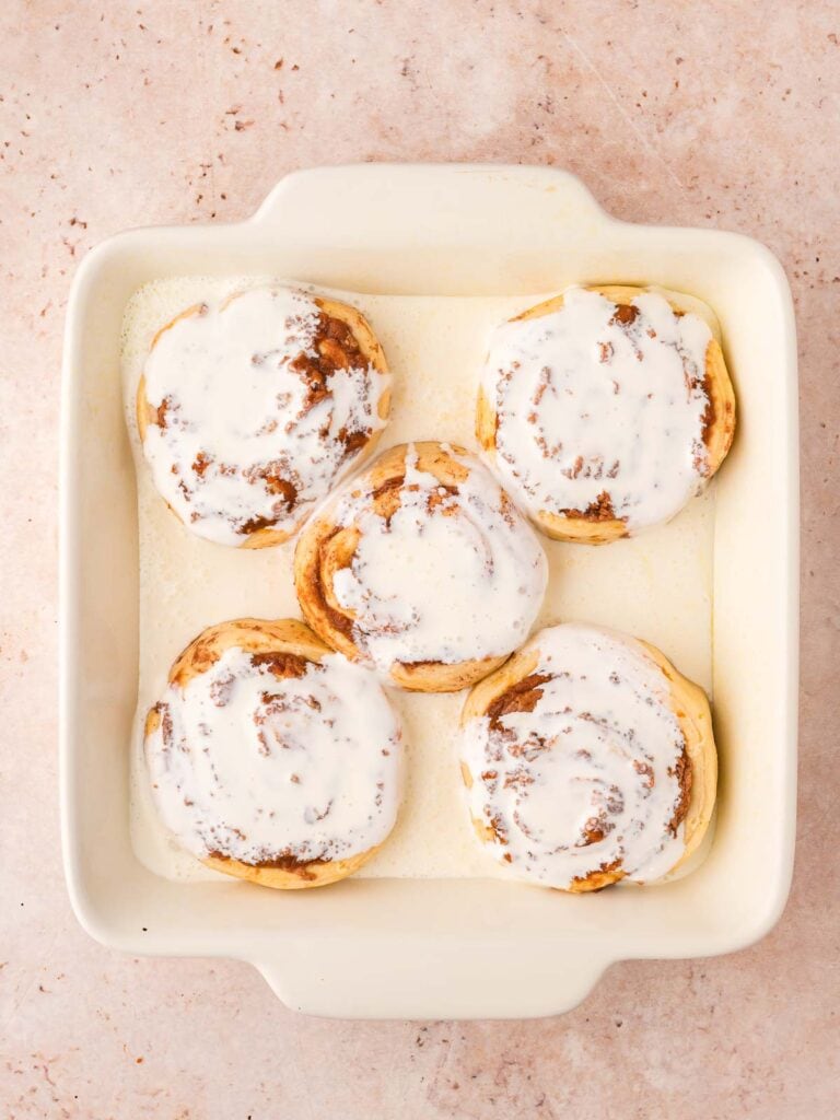 Cinnamon Rolls in a 8x8 dish with heavy cream poured on top.