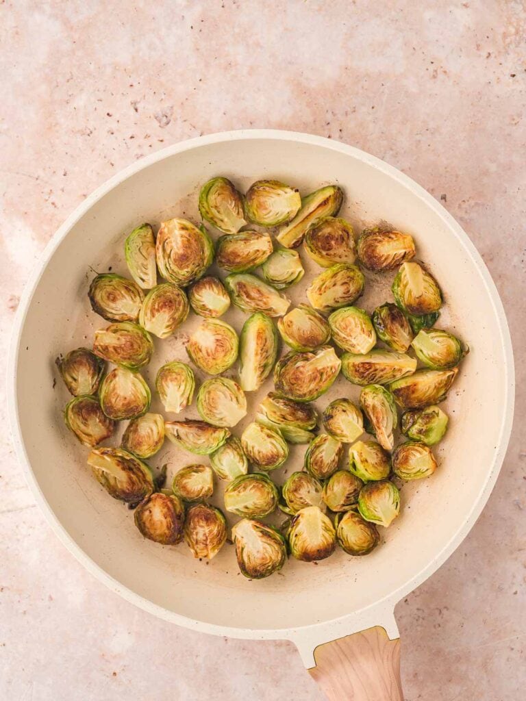 Brussels sprouts fried in a pan.