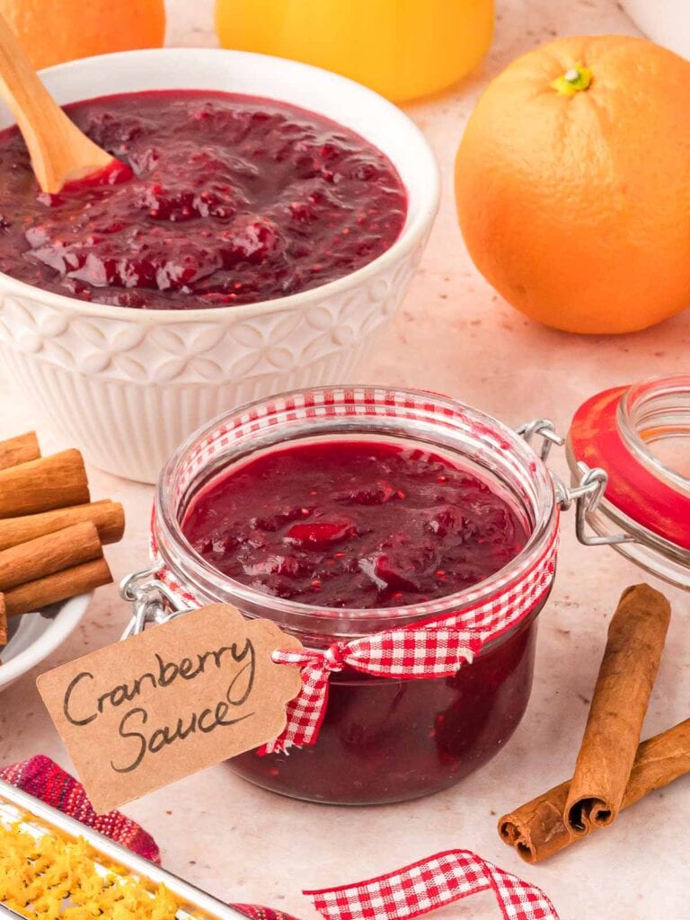 A jar of cranberry sauce and oranges.