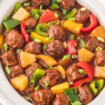 Up close photo ofFully cooked sweet and sour meatballs in a slow cooker.