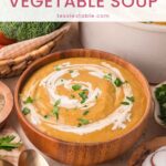 Wooden bowl of creamy vegetable soup with broccoli, carrots and crusty bread, a light and healthy meal by Tessie's Table.