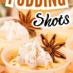 Small cups of eggnog pudding shots with whipped cream on a holiday tray.