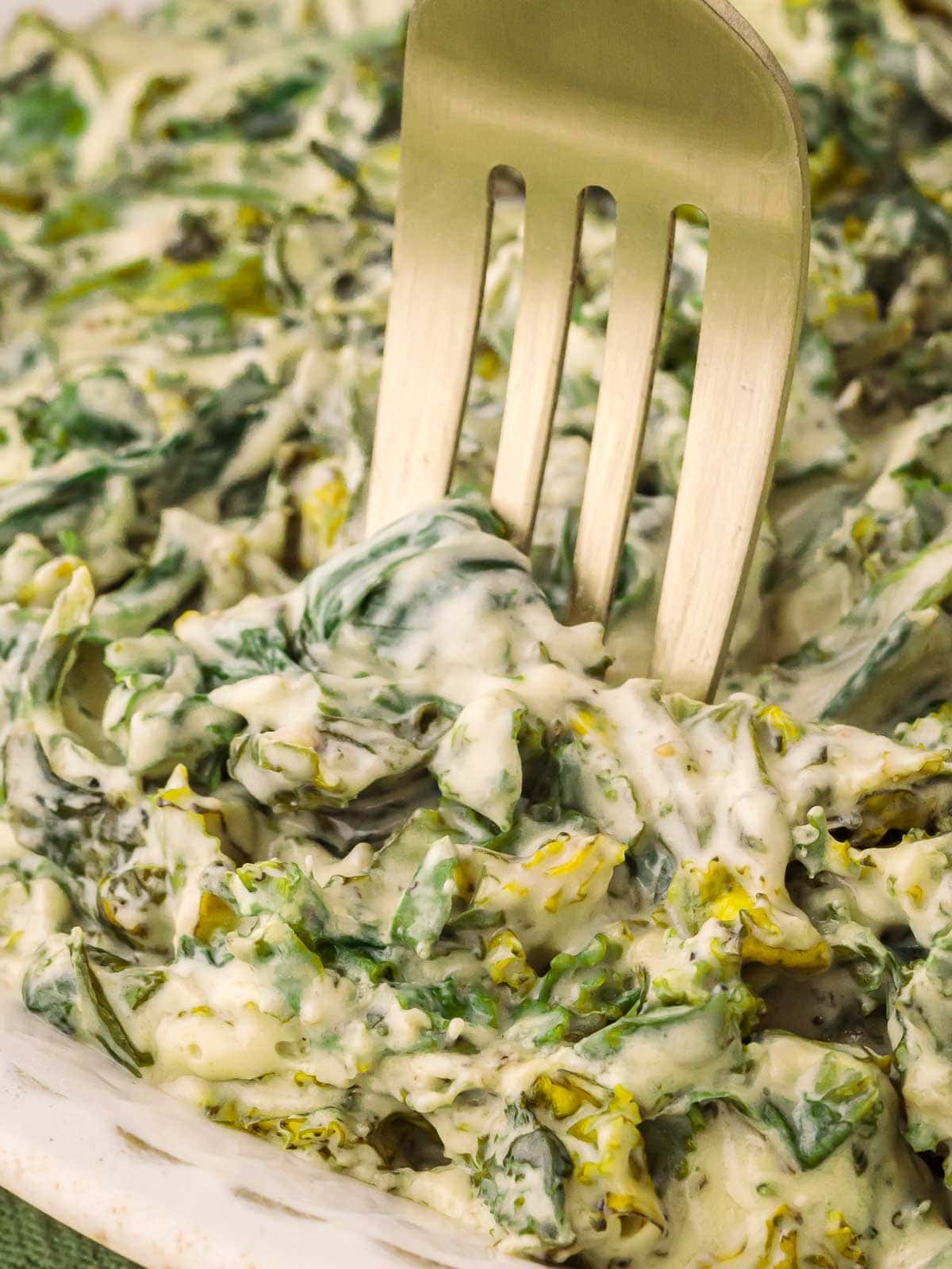 A fork placed into the Creamed Kale.