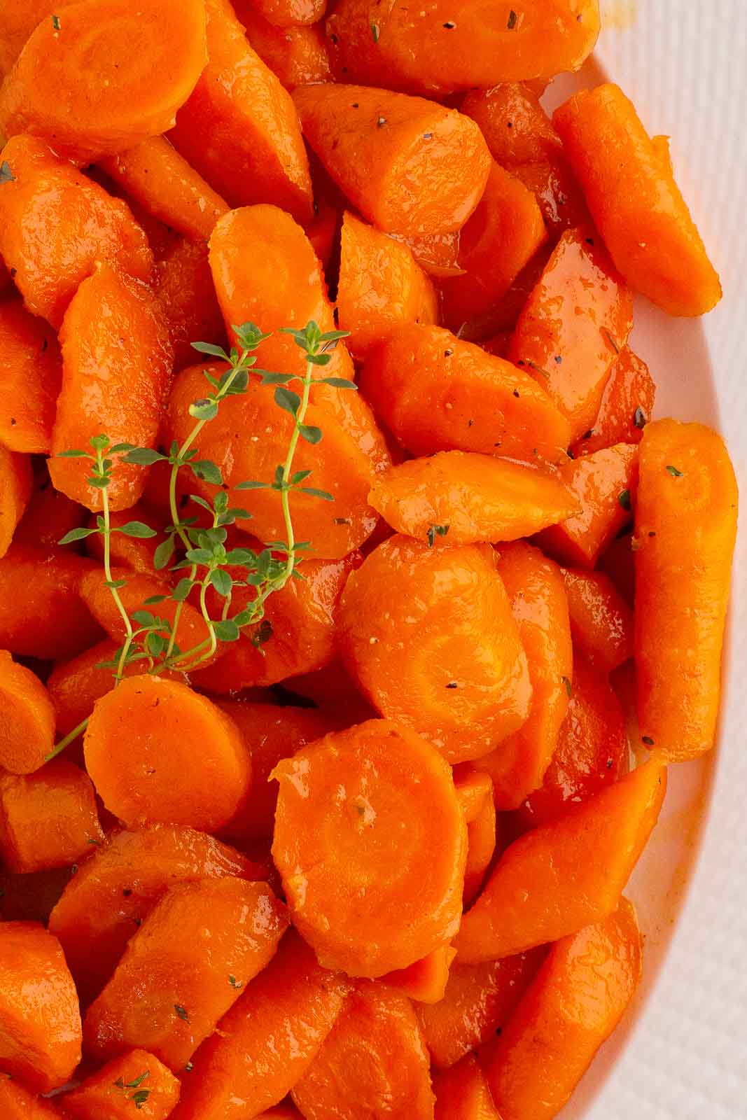 Up close od Honey Glazed Carrots. in a white serving dish.