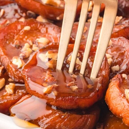 Up close of a fork sticking into Maple Roasted Sweet Potatoes.