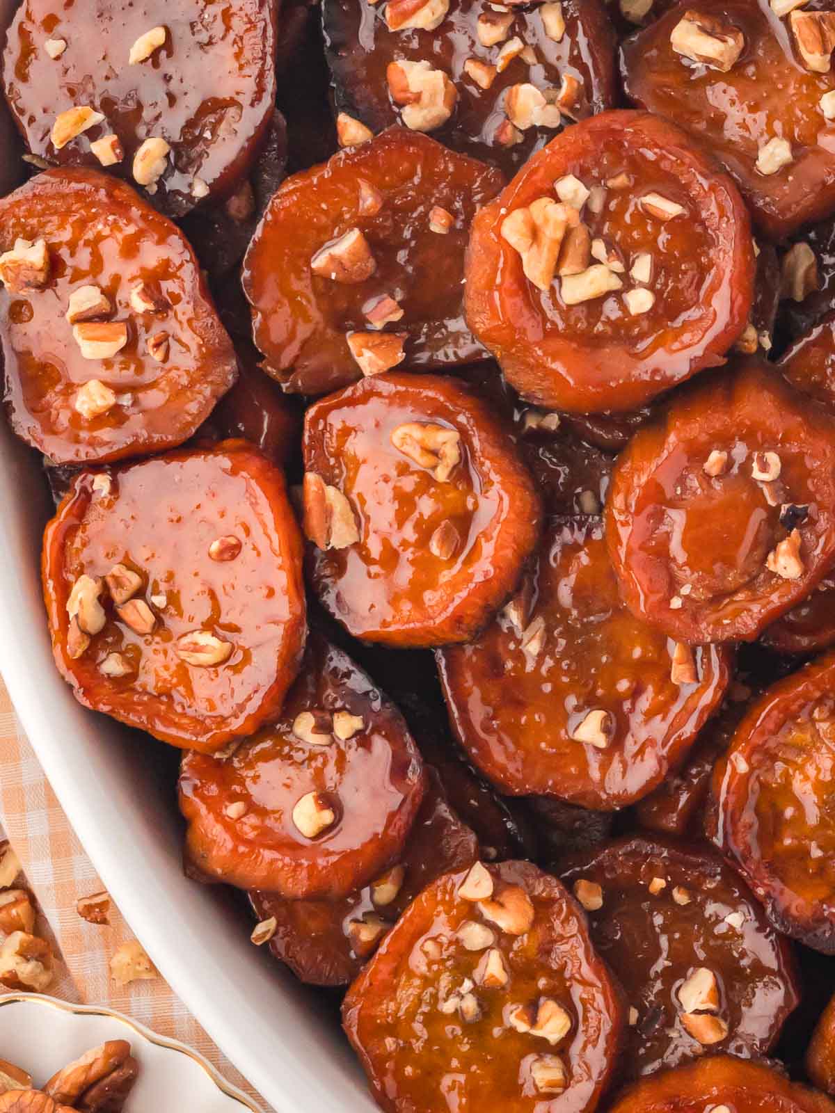 Up close of Maple Roasted Sweet Potatoes in a white serving dish.