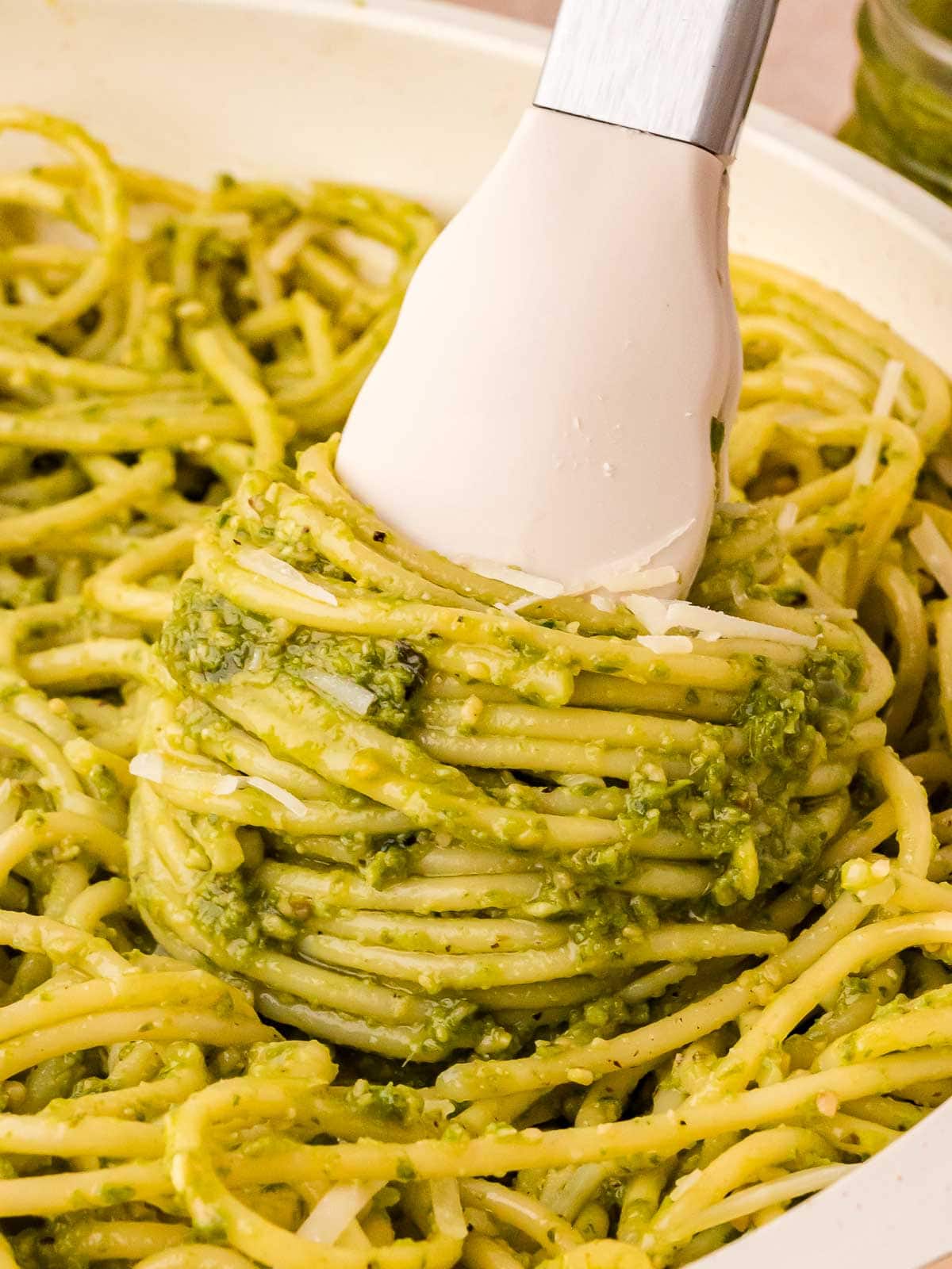 Pesto Pasta twisted with tongs.