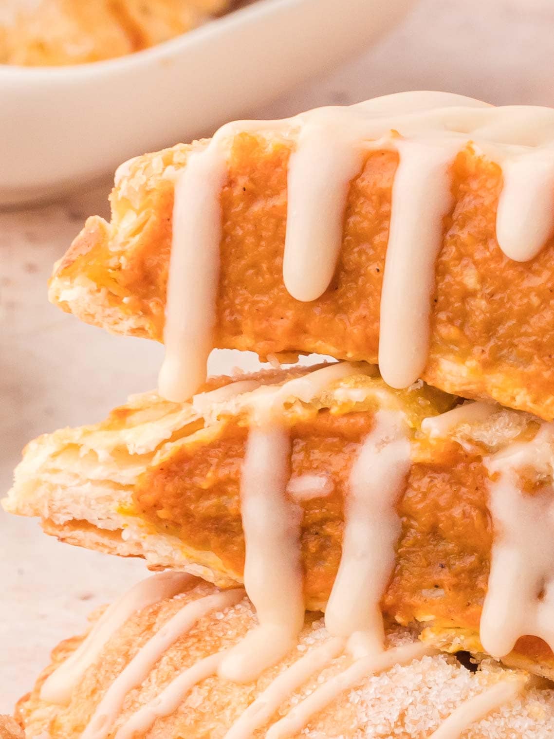 Inside shot of Pumpkin hand pies with maple glaze with the glaze running down the pie.