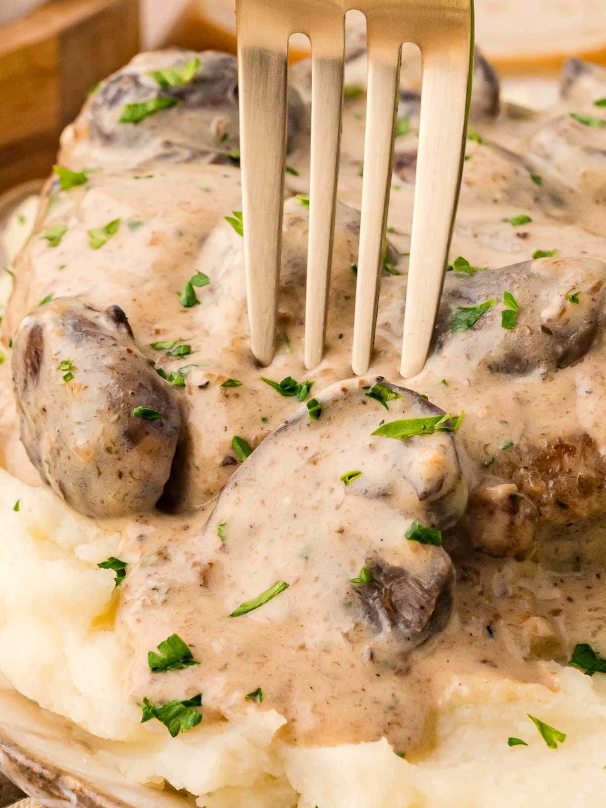 A fork being put into the Smothered Pork Chop.