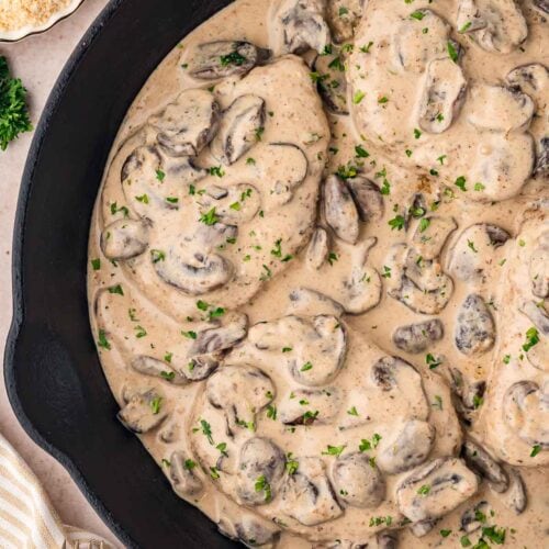 Up close of Smothered Pork Chop in a cast iron skillet.