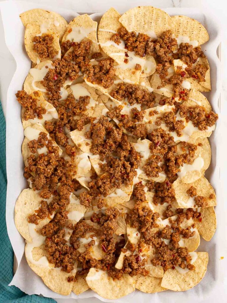 Tortilla Chips in a tray with queso and ground beef.