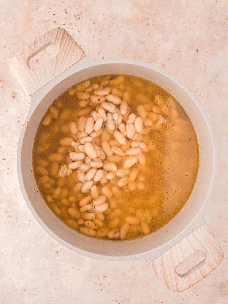 The white beans and broth added to the pot.