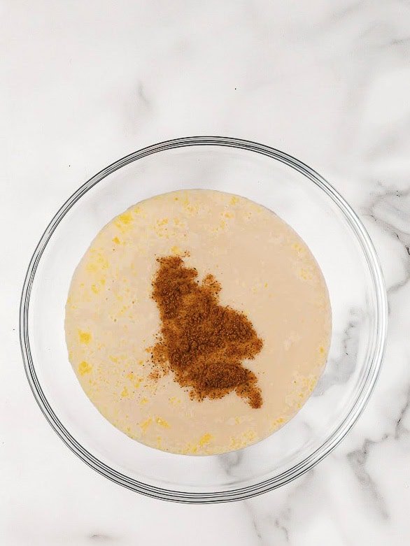 A large bowl with pudding mix, rum, eggnog, milk, and 1 tsp nutmeg.