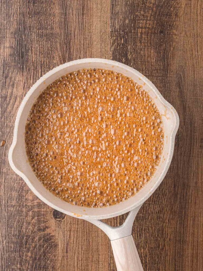 A large saucepan with butter and maple syrup boiling.