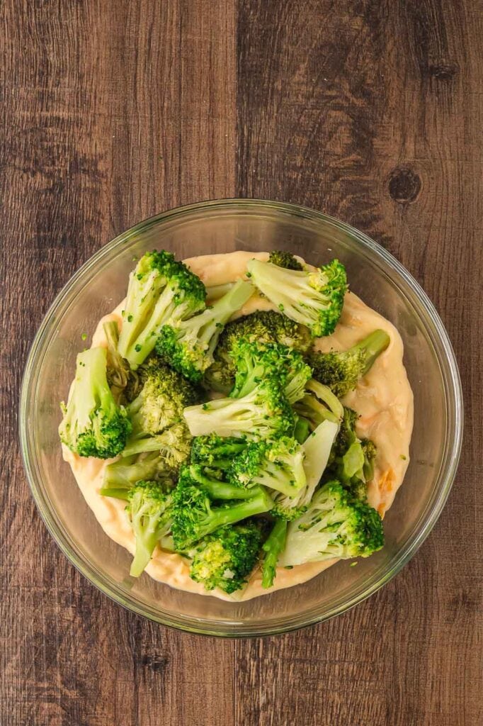 Mixing the broccoli into the wet ingredients to make Southern Broccoli Casserole.