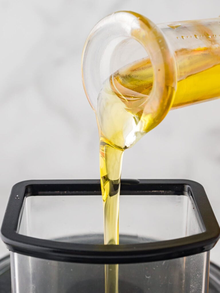 Oil being poured into a feed blender.