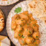 A plate with Slow Cooker Butter Chicken Meatballs and rice on it.