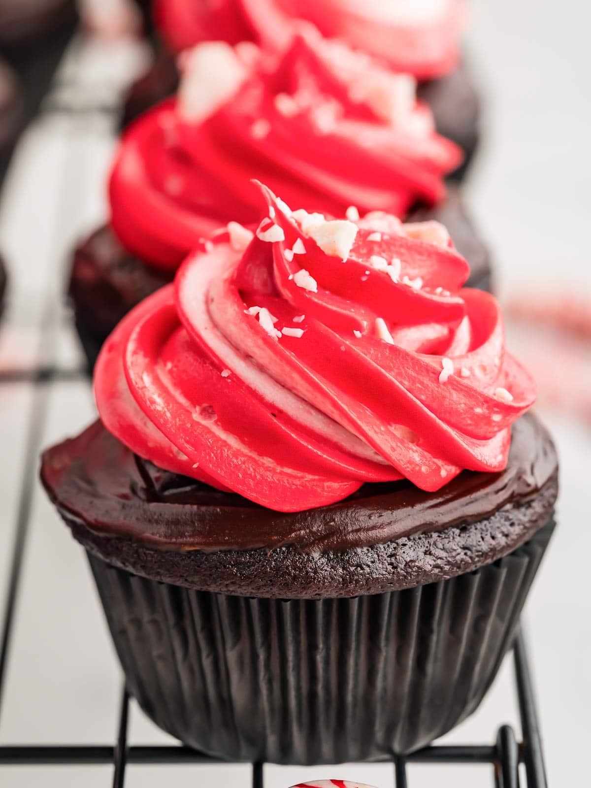 A line of Chocolate Peppermint Cupcakes on a wire rack.