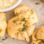 Up close of Homemade Garlic Knots with parmesan cheese in a bowl.