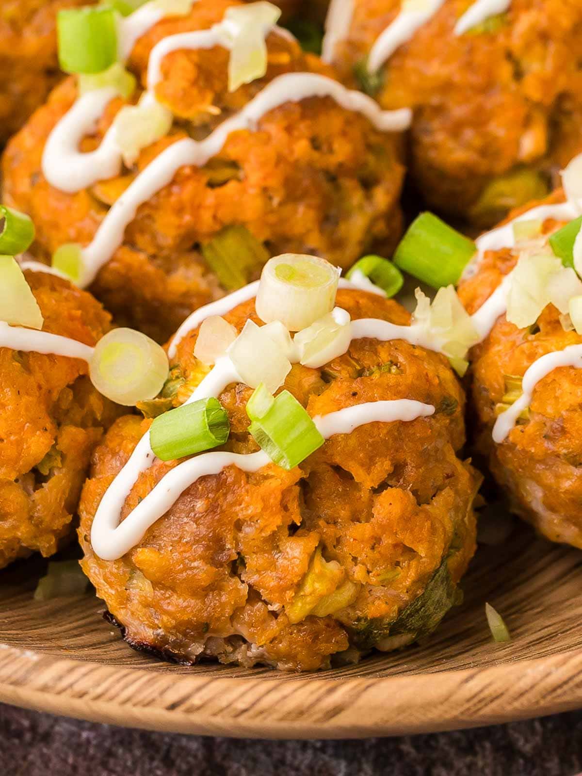 Up close of Buffalo Chicken Meatballs with green onion and ranch sauce.