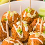 Buffalo Chicken Meatballs in a white bowl with toothpicks.