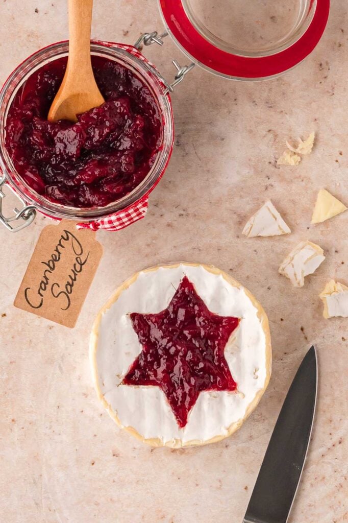 A star shaped cut out of the brie cheese and filled with cranberry sauce.