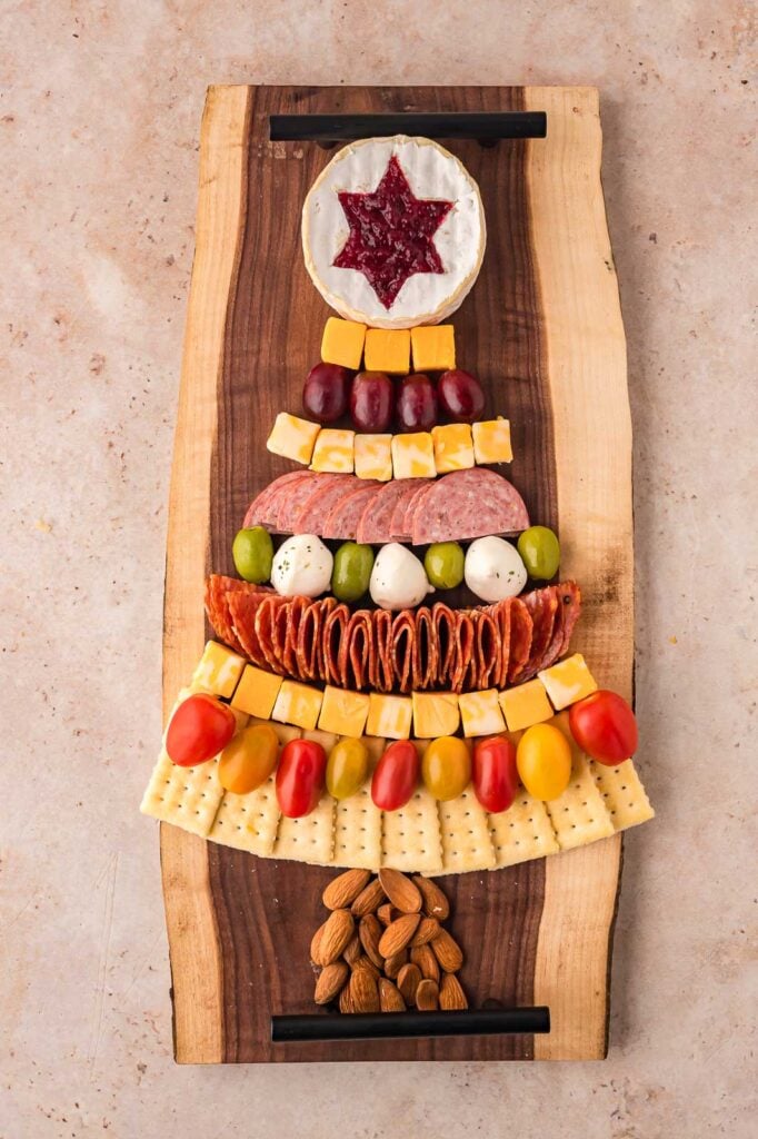 All the rows of food completed to make the shape of a Christmas Tree Charcuterie Board .