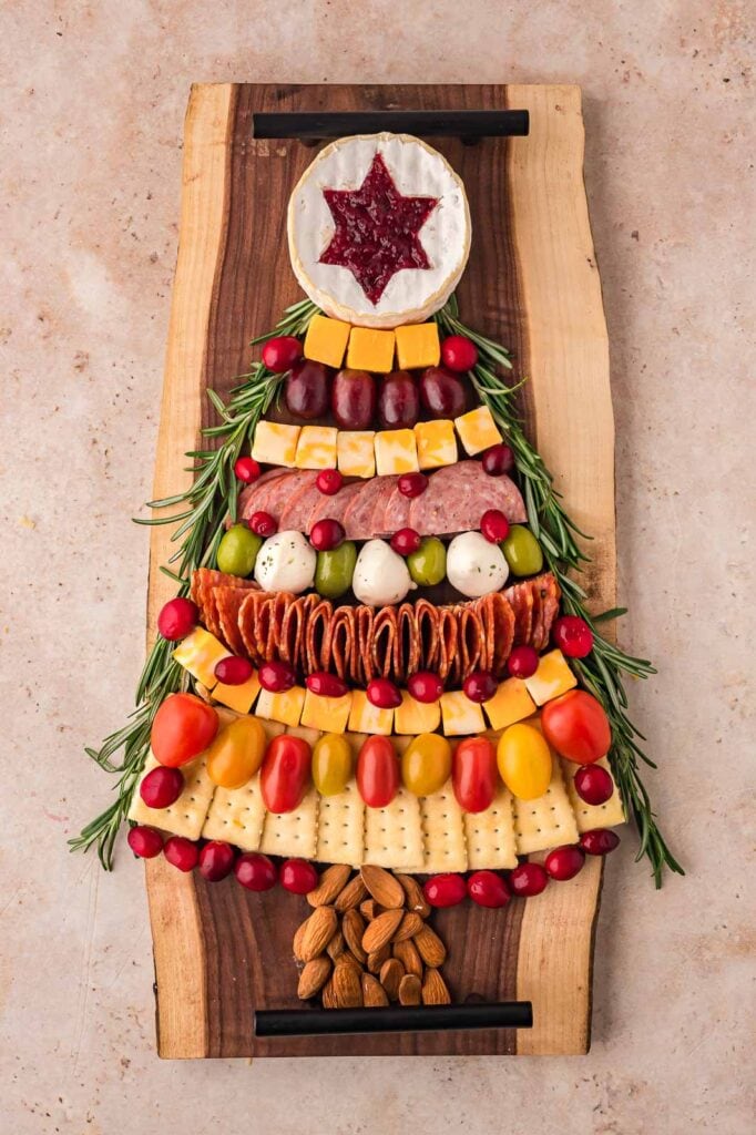 Fully decorated Christmas Tree Charcuterie Board with springs of rosemary and cranberries.