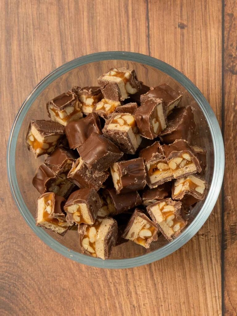 Chopped Snickers bars in a bowl.