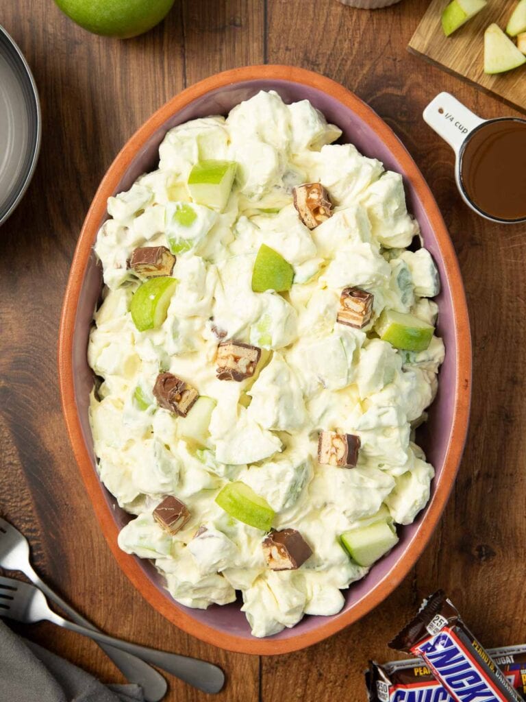 The Snickers salad in a serving bowl before the caramel sauce in poured on top.