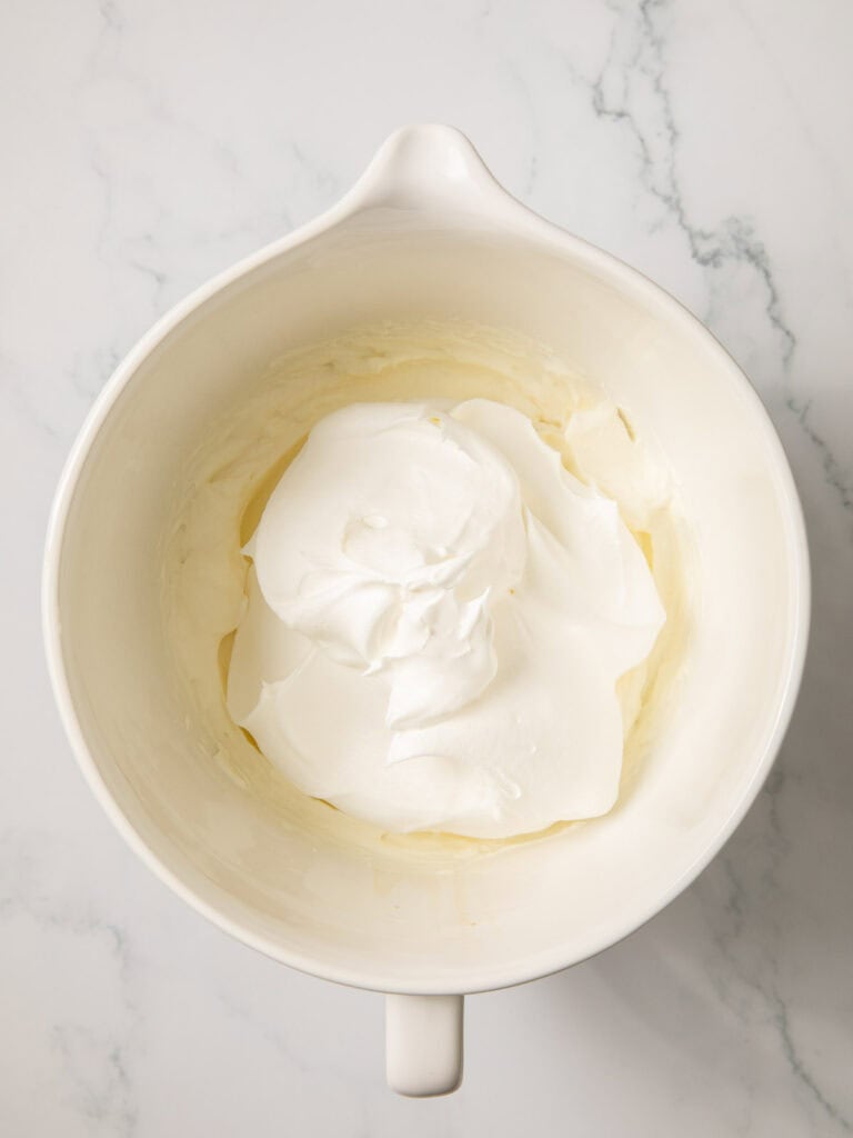 Cool whip on top of the whipped cream in a bowl.