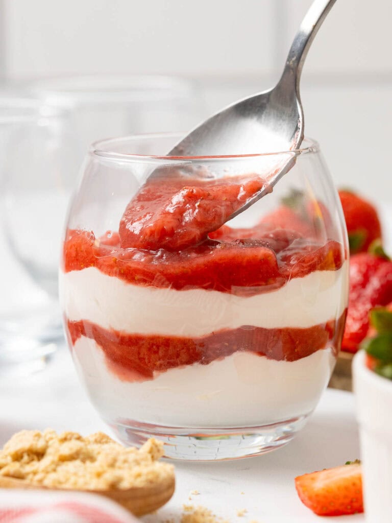 Filling the layers of Strawberries and cream into a glace.