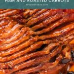 Close-up of spiral-cut orange honey glazed ham with cranberries, rosemary and roasted carrots by Tessie's Table.