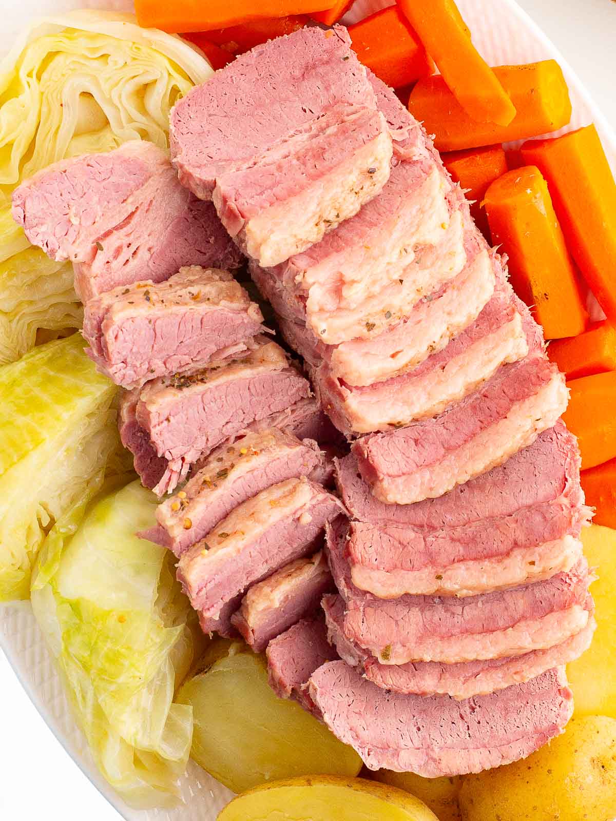 Corned Beef and cabbage with potatoes and carrots on a serving platter.