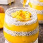 Honey being poured onto a layers of Mango Chia Pudding.