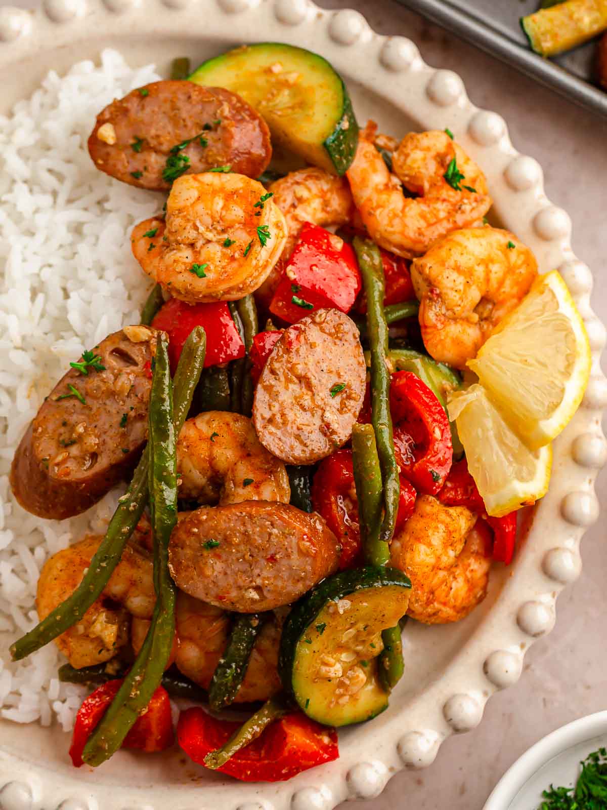 Up close of shrimp and veggies served with rice on a white plate.