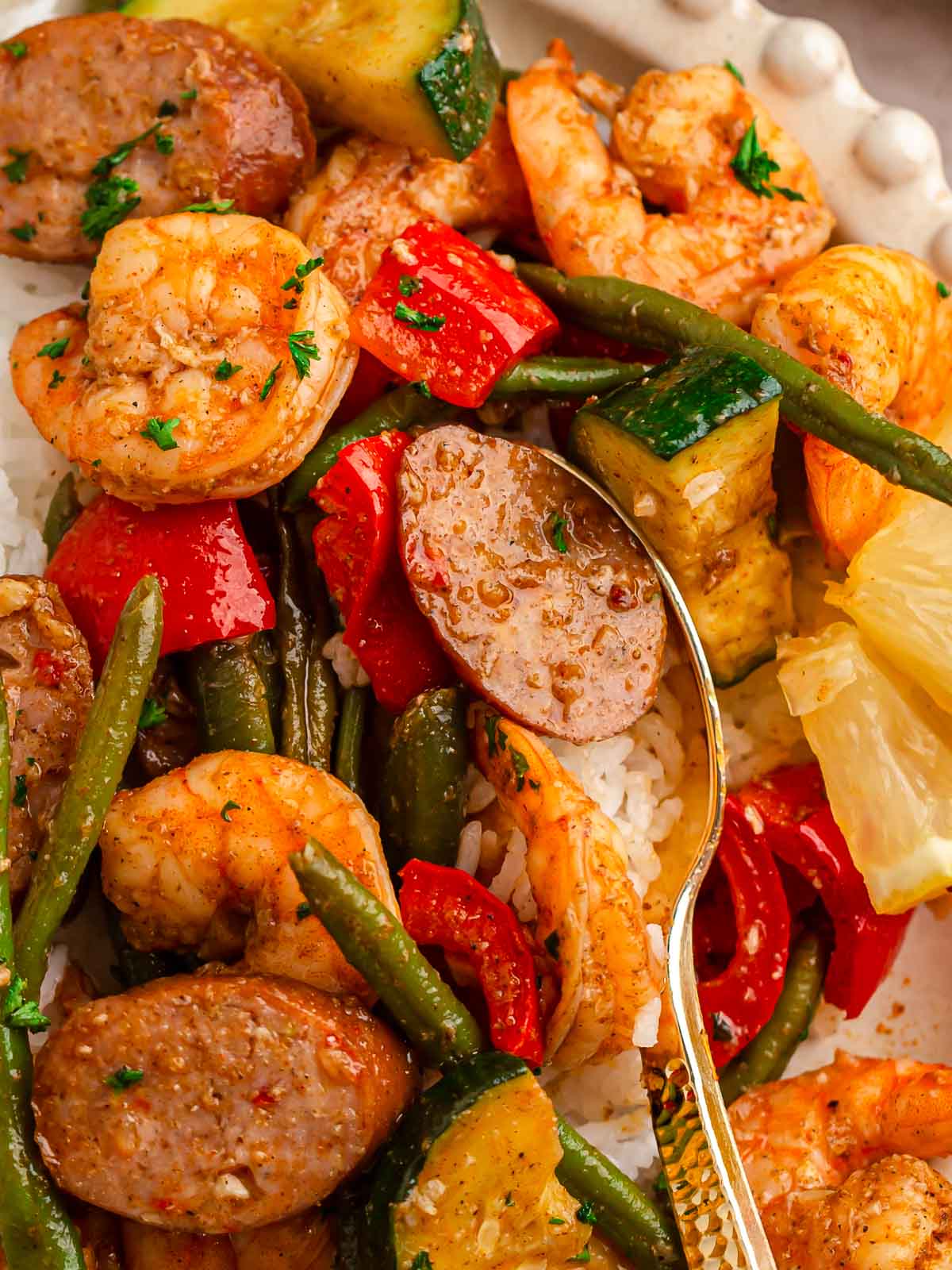 A spoonful of shrimp, sausage and veggies.