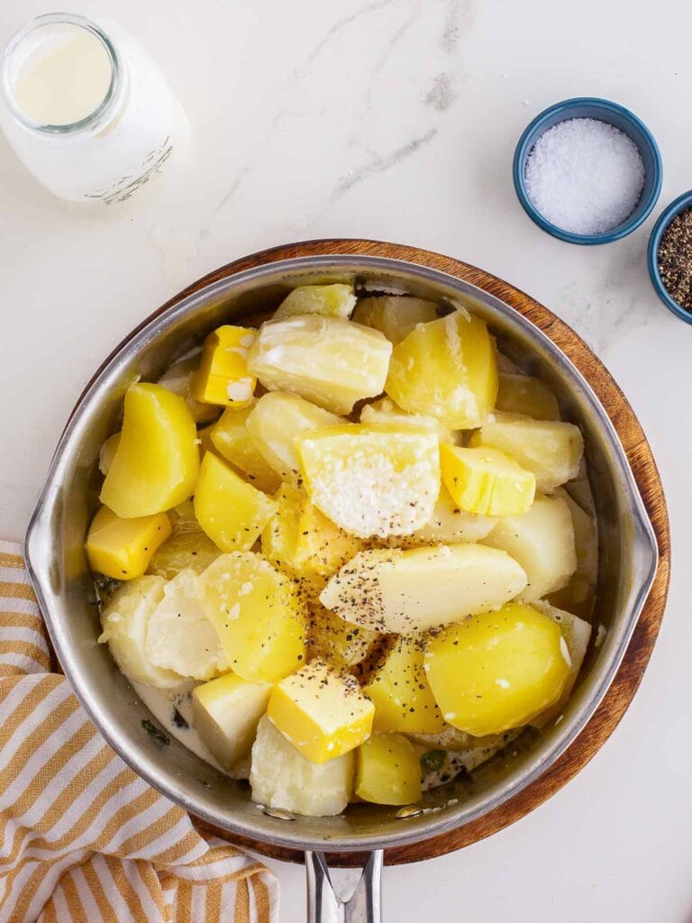 Cooke potatoes in a pot with salt, pepper and milk.