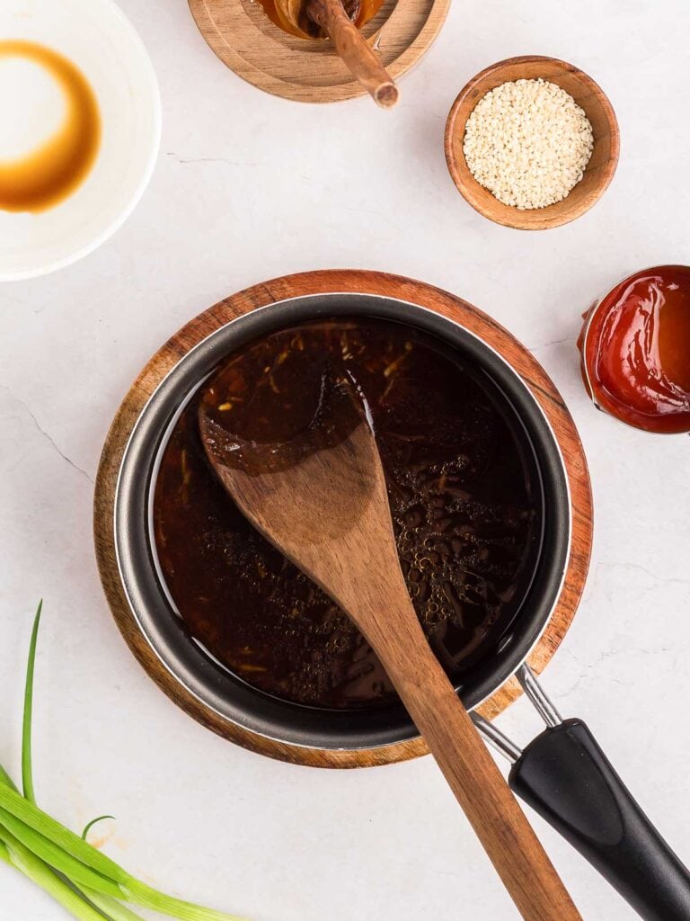 The sauce for honey garlic chicken wings being cooked in a pot.