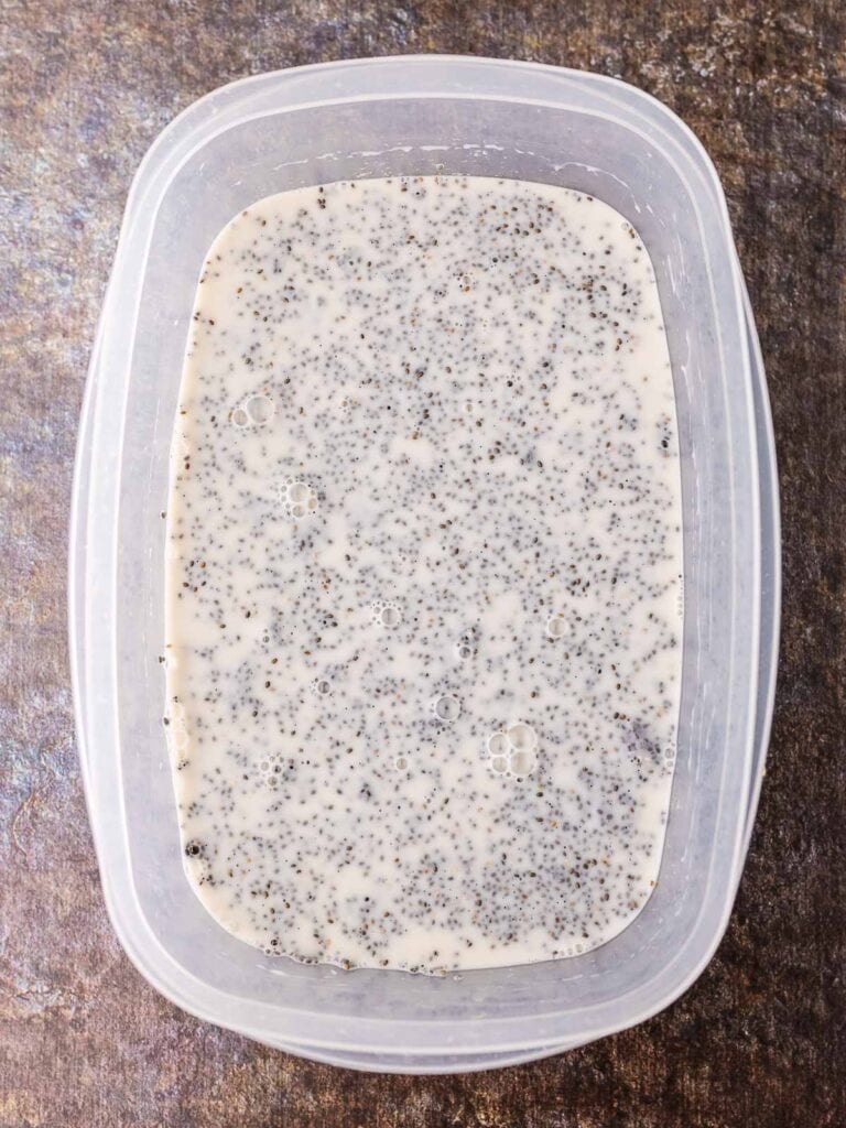 Chia seeds, milk, honey and vanilla mixed together in a container.