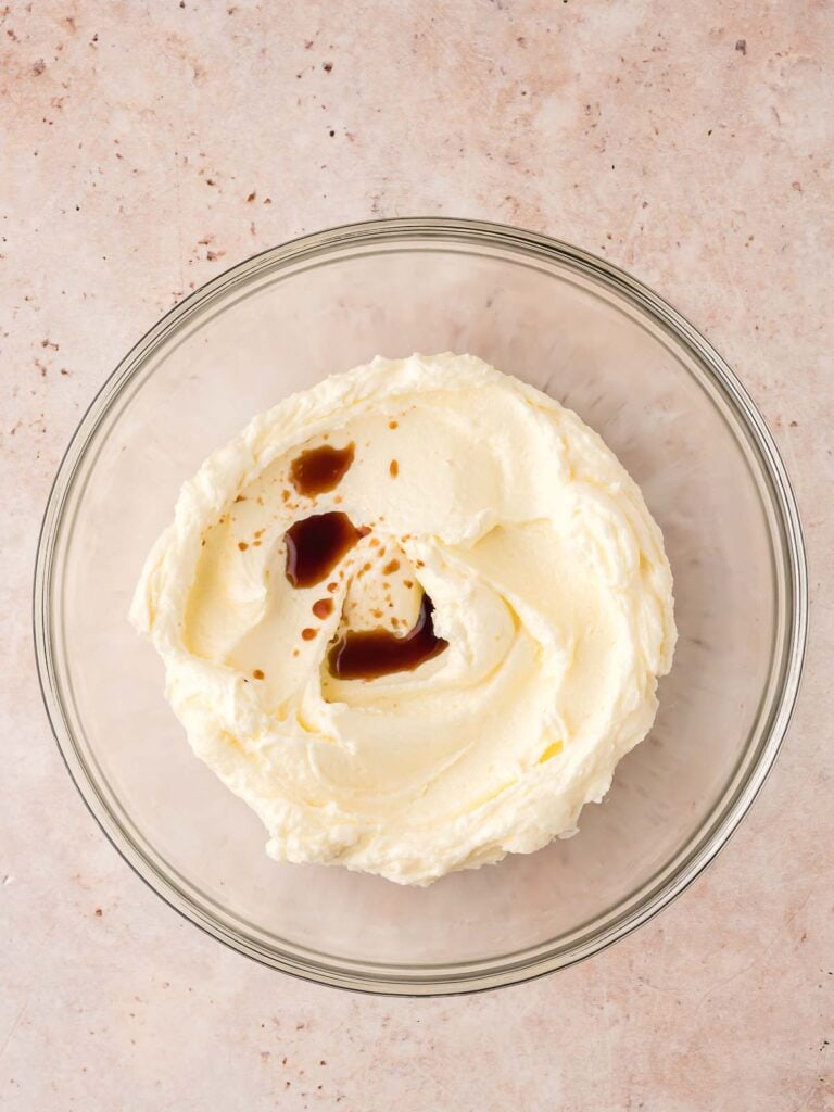 Butter and sugar mixed in a bowl with vanilla.