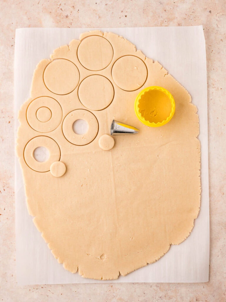 Cookies being cut out of the shortbread dough.