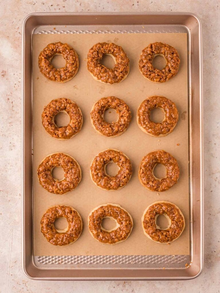 Samoas cookies with the coconut mixture molded onto the cookies, resting on parchment paper.