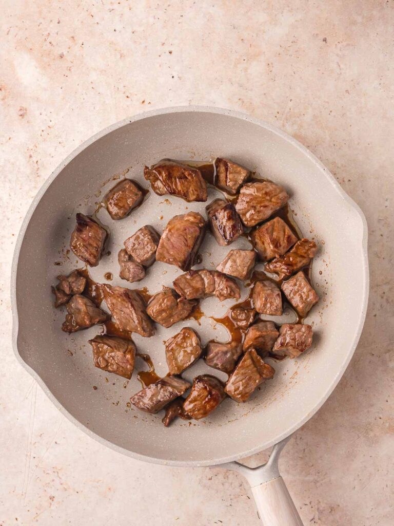 Browning beef in a pan.