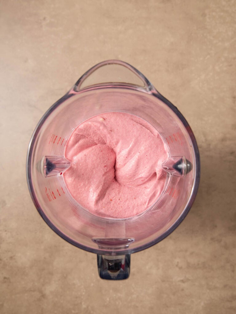 All the ingredients for a smoothie bowl blended in a blender.