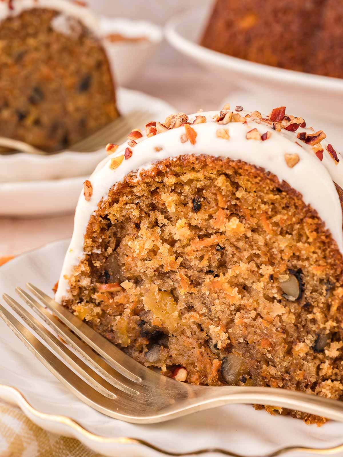 A slice of carrot bunt cake with a fork beside it.